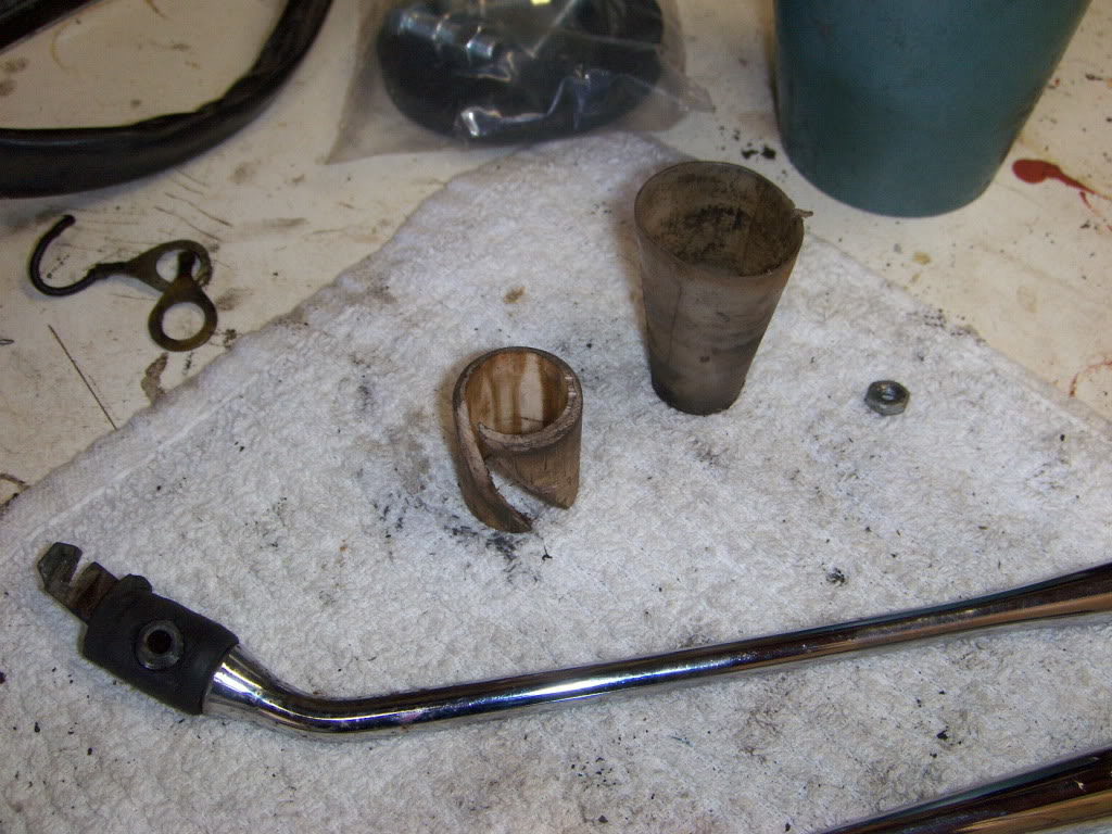 The centering cone is cracked and worn. The white plastic piece with the spiral cut in it appears to be part of a pvc pipe. It was stuck in the shift tube and may have been used as a lower bearing--there was no bearing at the bottom end. That little nut was used as a shim between the shifter lever and the spring to keep the notched lever pushed up against the detents.